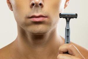 Man during shaving routine with a safety razor photo