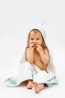 Cute baby wrapped into hooded towel after a bathing photo