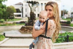 Beautiful mother with her baby son on the street photo