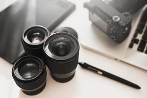 Workplace with a modern equipment for photography. Mirrorless camera and prime lenses. photo