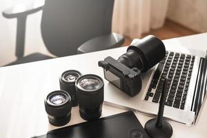 Workplace with a modern equipment for photography. Mirrorless camera and prime lenses. photo