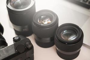 Workplace with a modern equipment for photography. Mirrorless camera and prime lenses. photo