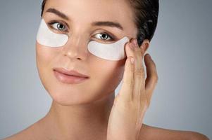 Woman with hydrating eye patches under her eyes o photo