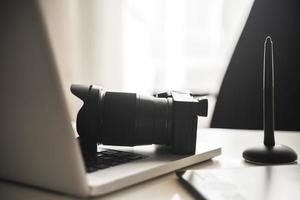 lugar de trabajo del fotógrafo con una cámara sin espejo, una computadora portátil y una tableta gráfica foto