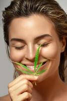 CBD cosmetics concept. Beautiful woman with a cannabis leaf photo