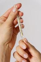 Close up of female hands with a thermometer photo