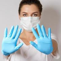 Woman is wearing a face mask and latex gloves for protection against virus photo