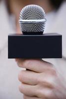 Closeup female hands with a reporter microphone photo