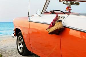 Retro car with tied boots and bandana to a door handle photo