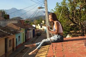 Young woman is sitting on the roof of old house photo