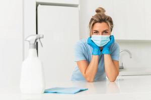 Woman worker wearing prevention mask and gloves during apartment cleaning photo