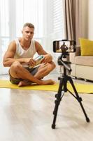 Fitness blogger streaming or recording video for his subscribers photo