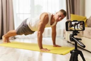 Fitness blogger streaming or recording video for his subscribers photo