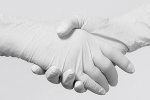 People wearing latex gloves greeting each other photo