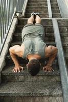 Muscular man is doing push-ups during calisthenic workout on a street photo