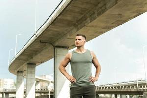 Young athletic man wearing khaki sportswear after his street workout photo