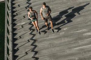 Sportive couple during workout stair running outdoors photo