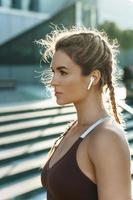 mujer deportiva escuchando música durante su entrenamiento de fitness al aire libre foto