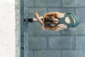 Sportive woman is stretching during fitness workout outdoors photo