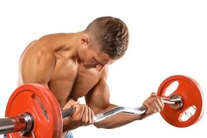 joven musculoso haciendo ejercicio de curl de barra de bíceps foto