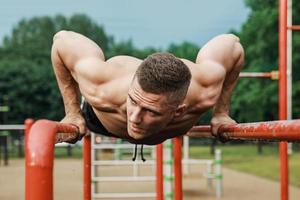 hombre musculoso durante su entrenamiento en la calle foto