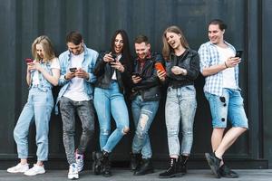 Group of young and stylish people using smartphones photo