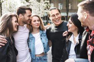 Group of best friends are having fun outdoors. Young people are happy to see each other during a meeting. photo