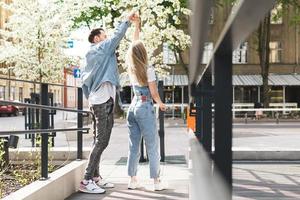 Young sensual and loving couple dancing during their date on a city street photo