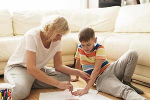 madre e hijo están dibujando juntos en casa foto