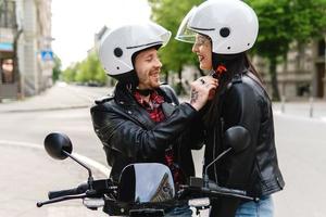 Stylish couple wearing motorcycle helmets before ride on electric scooter photo