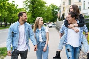 Group of best friends are having fun while walking by city street photo