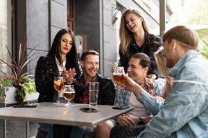 grupo de amigos beben cerveza y cócteles en un bar foto