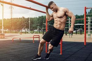 Muscular man during his workout on the street photo