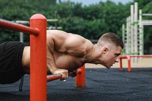 hombre musculoso durante su entrenamiento en la calle foto