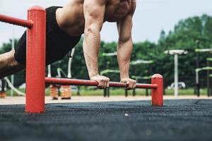 Muscular man during his workout on the street photo