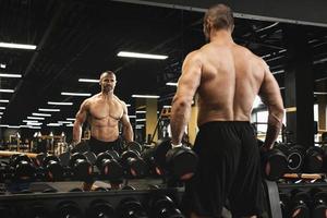 Muscular bodybuilder in a free weights zone in the gym photo