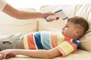 Mother measuring temperature of her son. photo