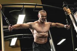 Muscular bodybuilder during his workout in the gym photo