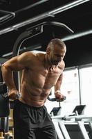 Muscular bodybuilder doing dips for triceps and chest muscles in the gym photo