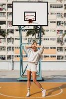 joven mujer con estilo está posando en la cancha de baloncesto choi hung estate foto