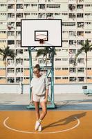 joven mujer con estilo está posando en la cancha de baloncesto choi hung estate foto