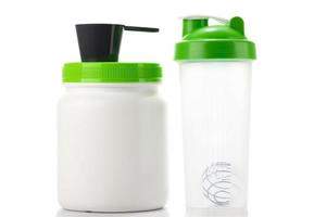 Green protein shaker, scoop and jar on white photo