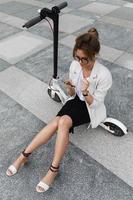 Beautiful businesswoman sitting on the electric scooter photo