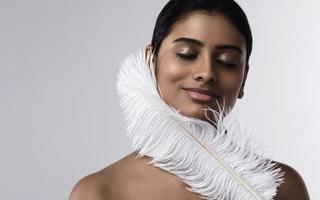 Young and sensual Indian woman with a soft ostrich feather photo