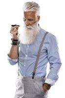 guapo senior hombre fumar tabaco sistema de calefacción foto