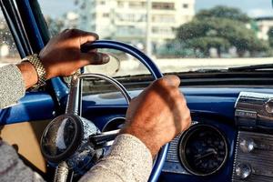 Driver's hands on the steering wheel of retro car photo