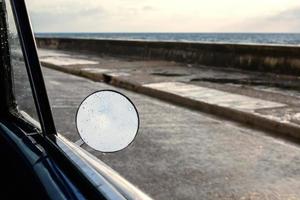Side mirror of the car with sea view photo