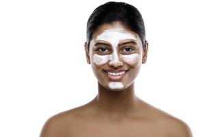 joven india con una máscara limpiadora aplicada en la cara foto