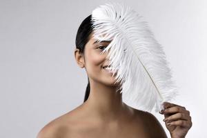 Young and sensual Indian woman with a soft ostrich feather photo