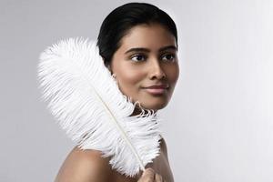 Young and sensual Indian woman with a soft ostrich feather photo